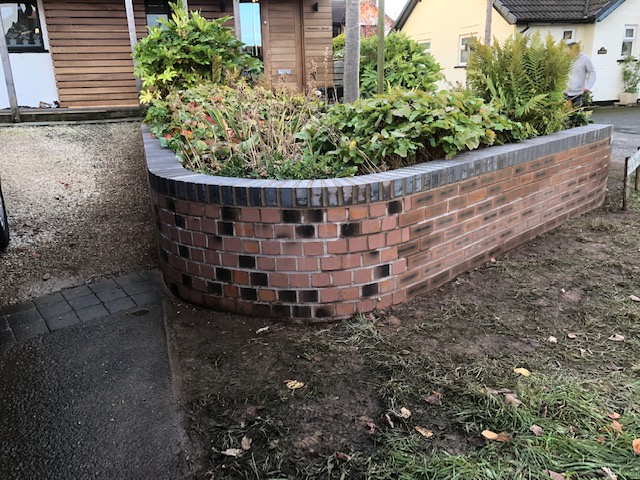 Rebuilt the collapsed outside skin of wall. Rebuilt in all new brick following the curve of current wall in Staffordshire blue heathers on top.